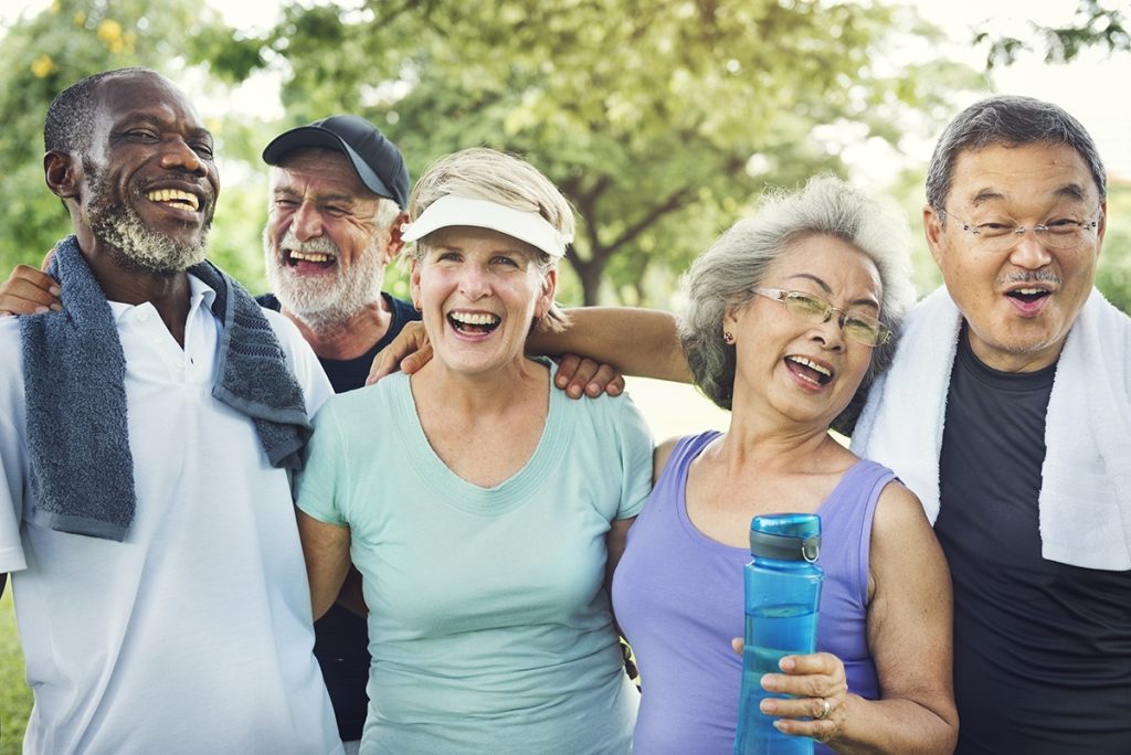 Group photo of happy seniors just finishing a jog together in a park