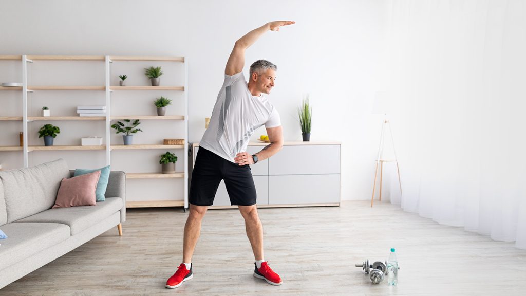 Middle aged man stretching in his living room