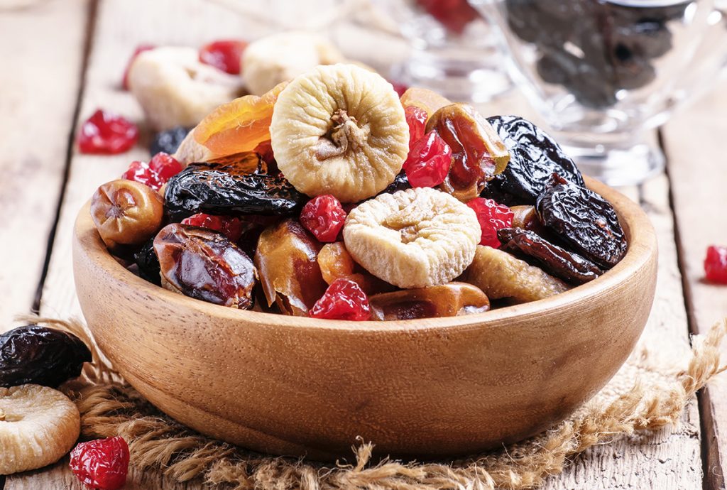 Variety of dried fruits in a wooden bowl