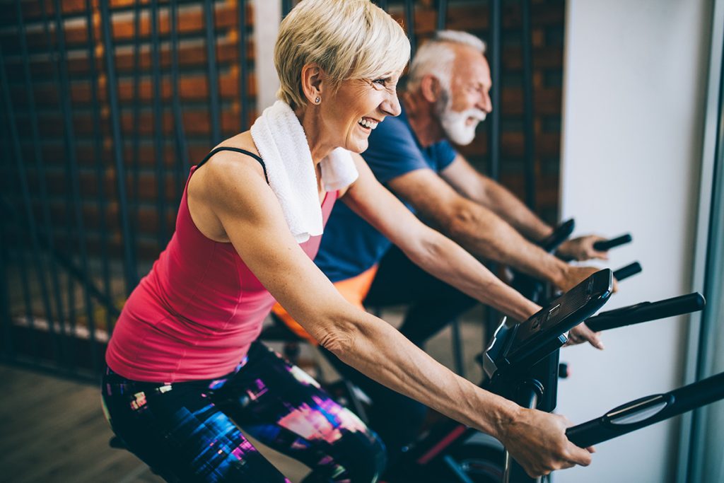 Older couple on a exercise bike at the gym