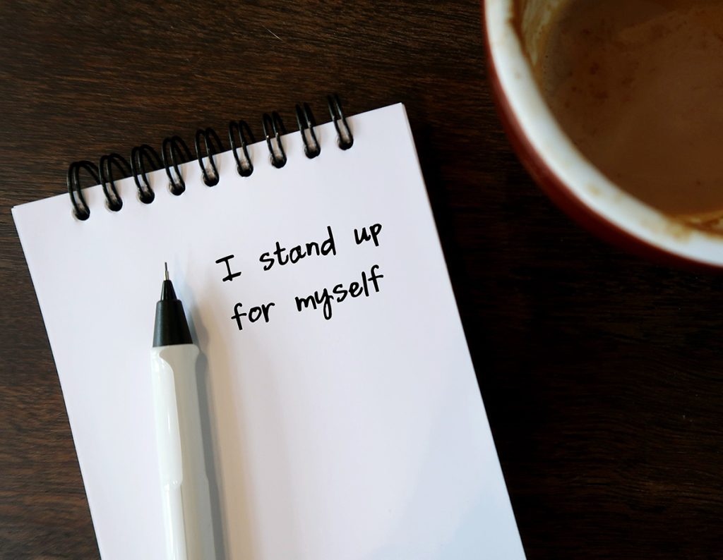 Pen and notepad that has "I stand up for myself" written on it