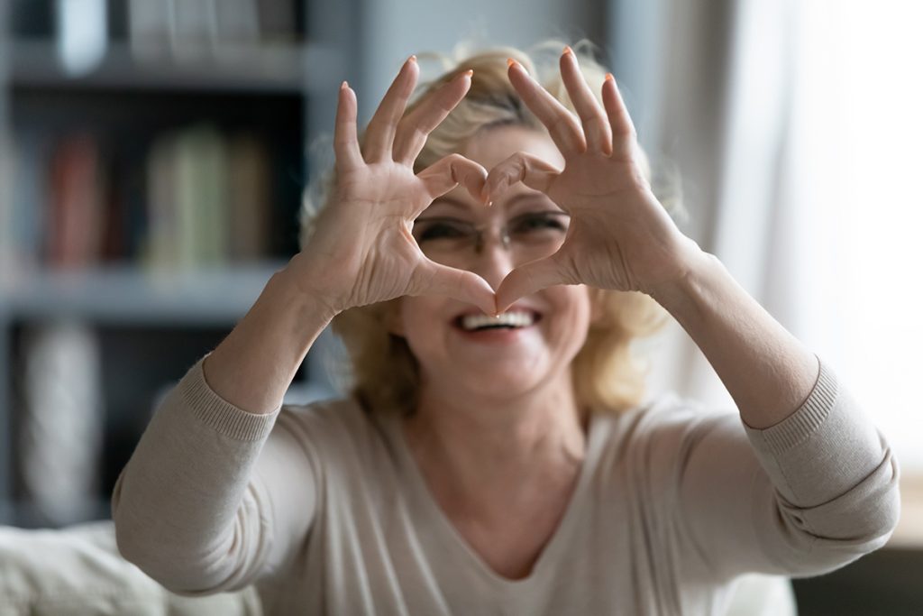 Older woman forming a heart with her hands 