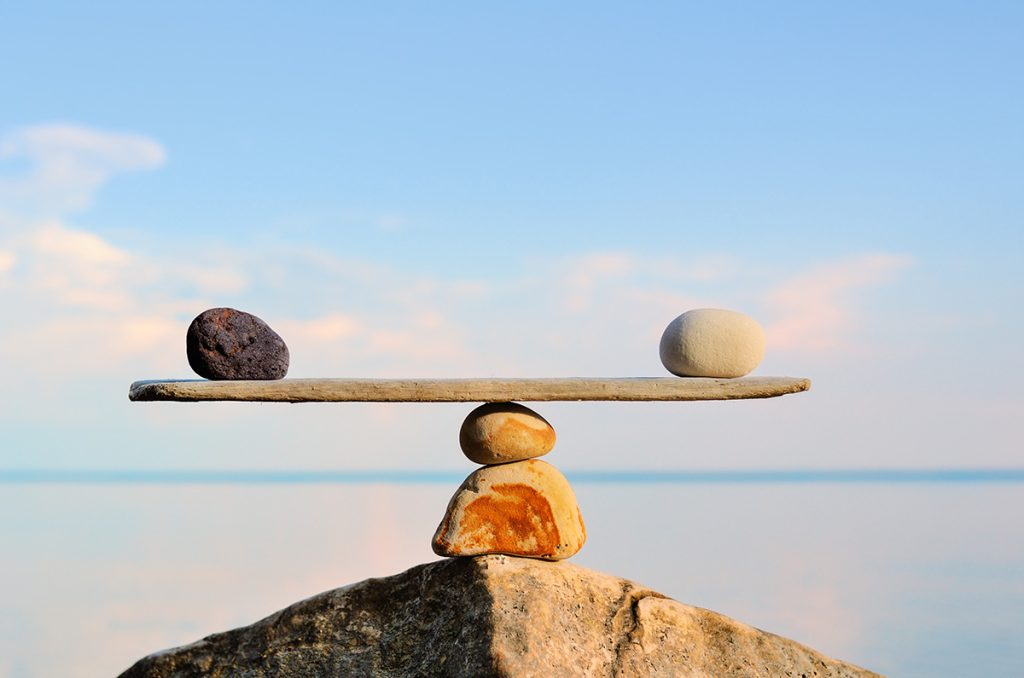 Rocks balancing on each other with a beach backdrop