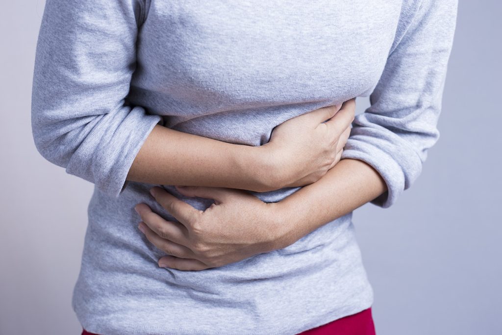 Woman holding her stomach from pain