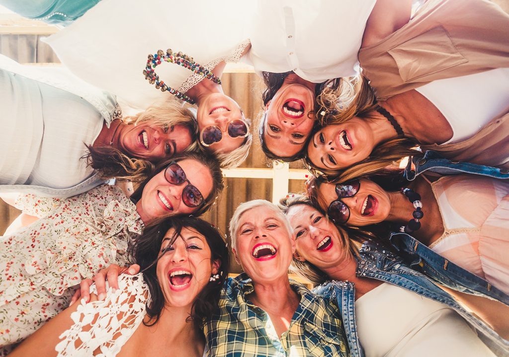 Bottom view of a group of older female friends who formed a circle and smiling