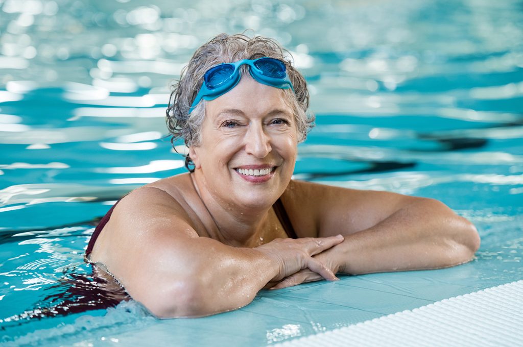 Older woman in the pool smiling 