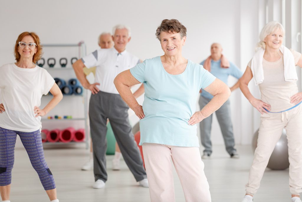 Group of active seniors exercising in fitness club