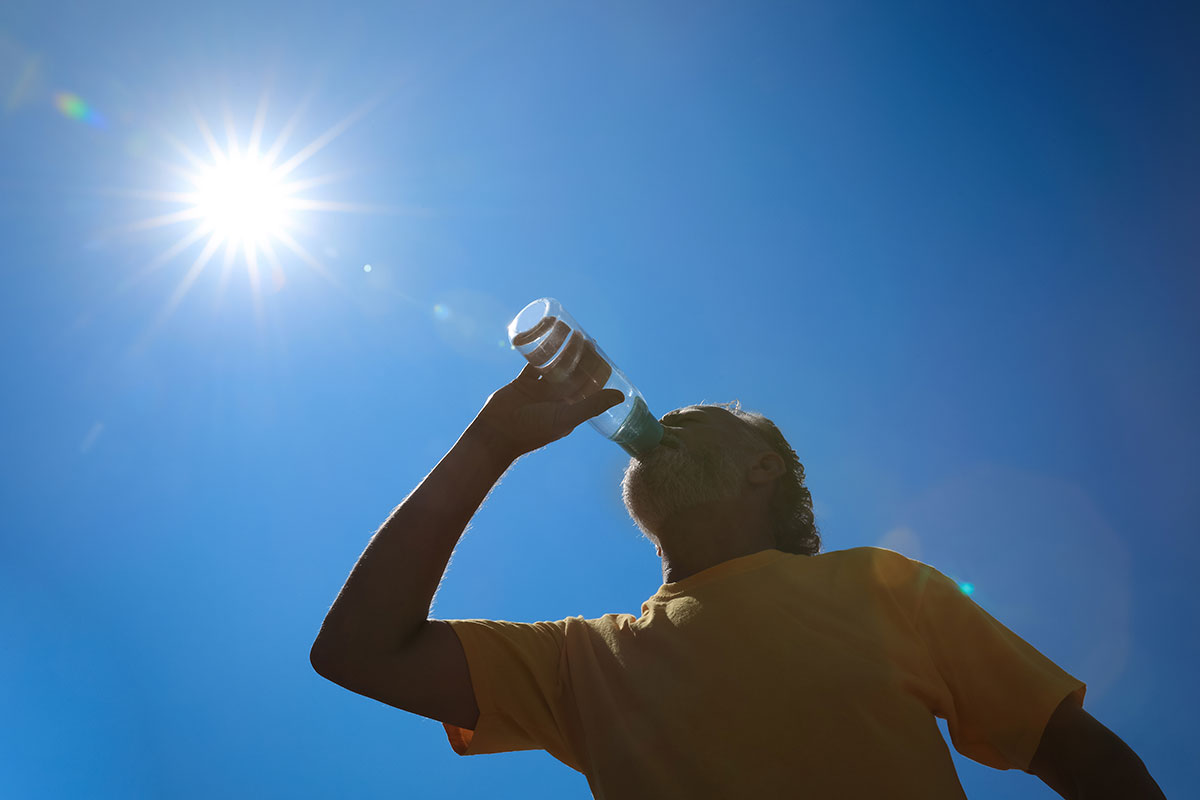 man drinking water in the sun