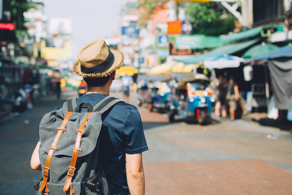 Man traveling backpacker in Khaosan Road outdoor market in Bangkok, Thailand