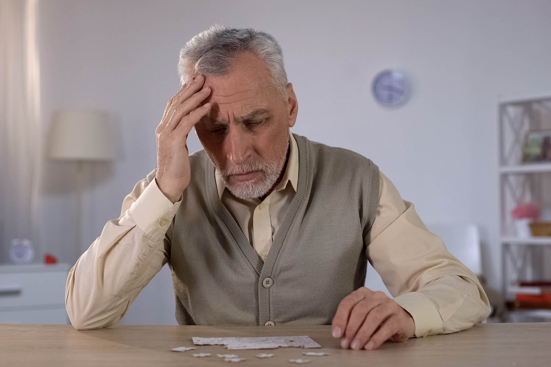 senior man trying to combine puzzle, having memory problems, cognitive impairment