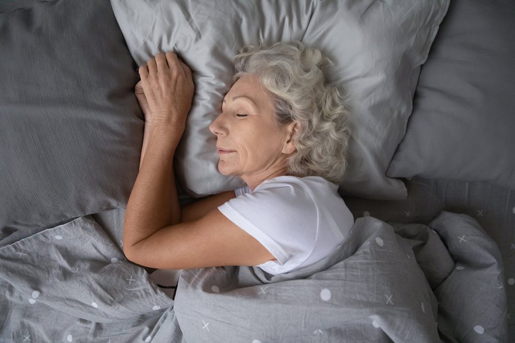 above view of older woman peacefully sleeping in bed
