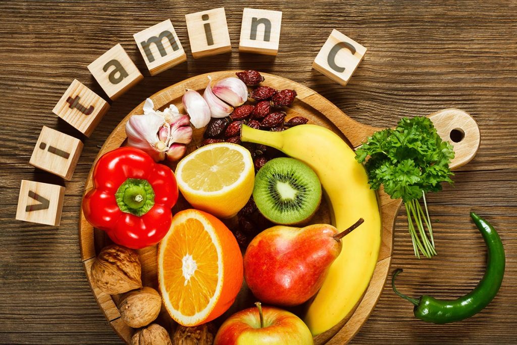 vitamin c spelled out in block letters. a bowl of fruits and vegetables