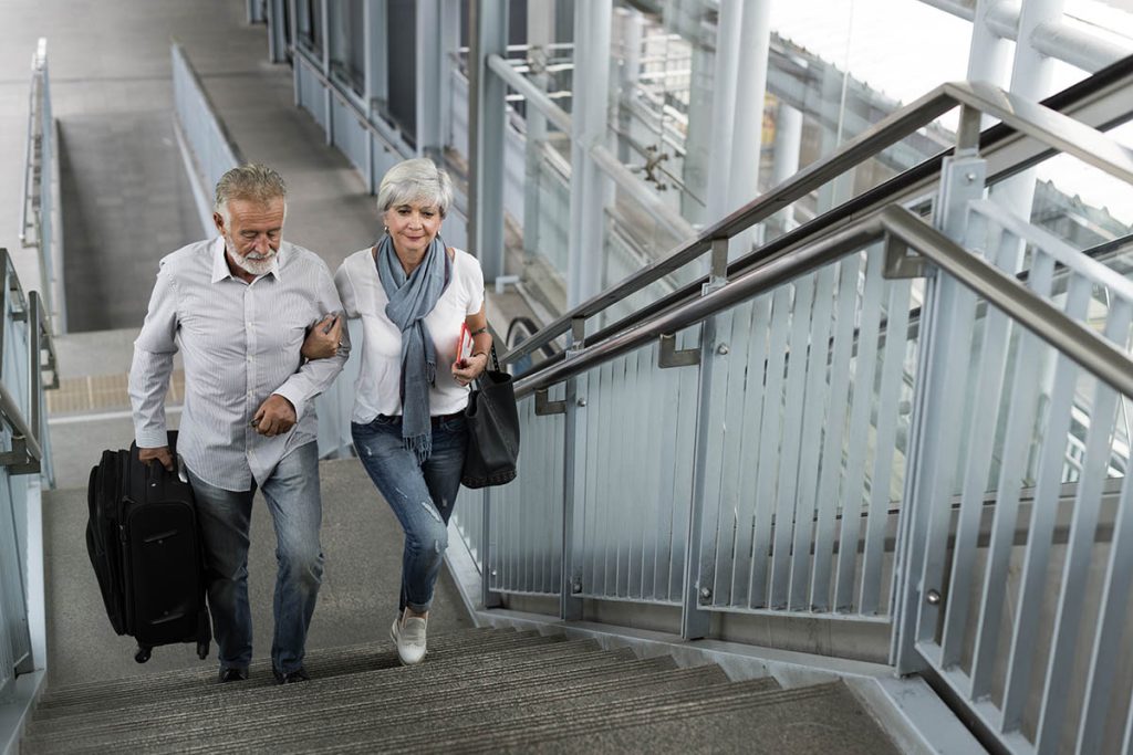 Senior couple traveling. Walking up stairs
