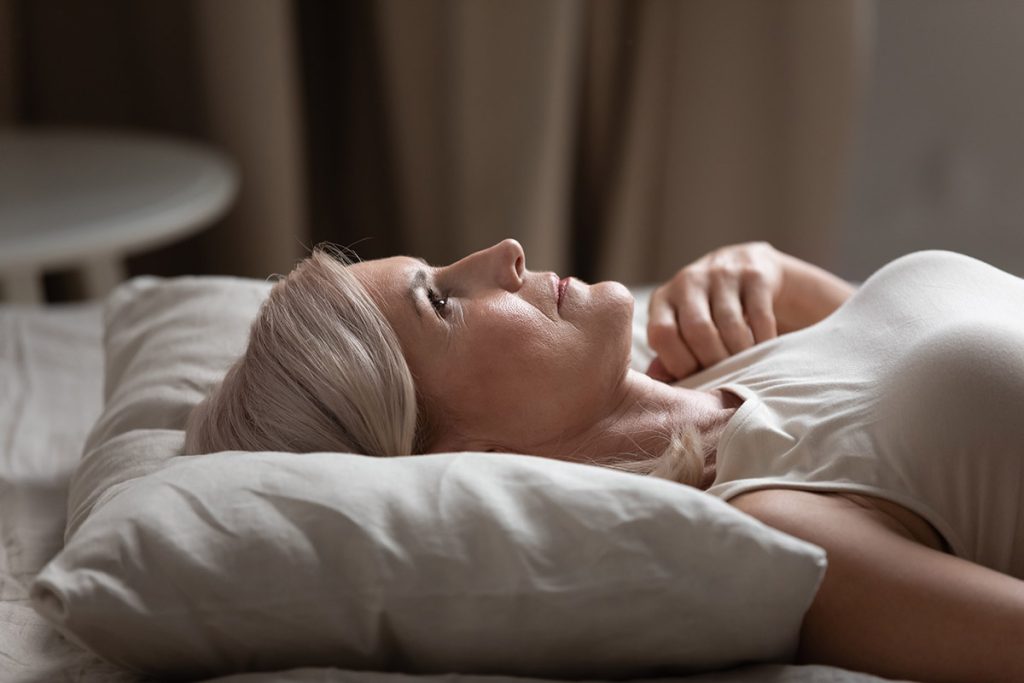 woman lying flat in bed