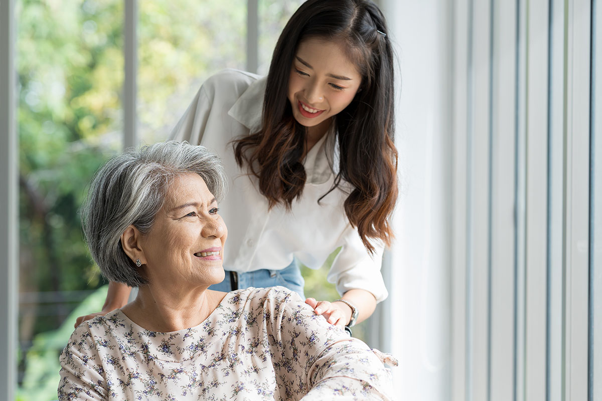 Young asian woman taking care elderly woman patient careful on wheelchair. Woman caring senior woman on wheelchair at nursing home.