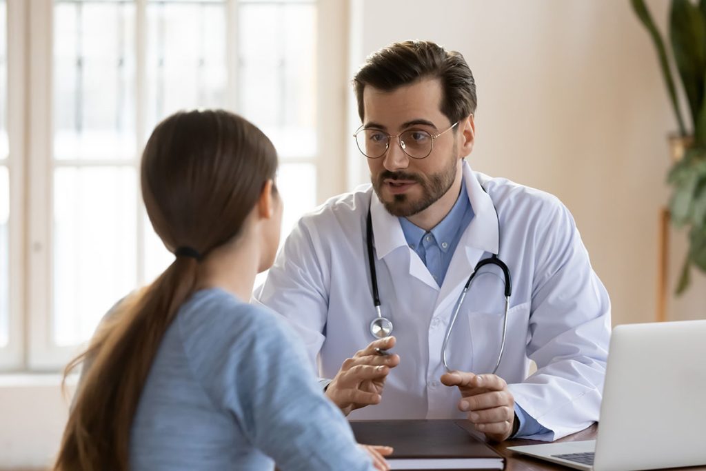 male doctor in white medical uniform talk discuss results or symptoms with female patient, man GP or physician consult woman client give recommendation at meeting in hospital