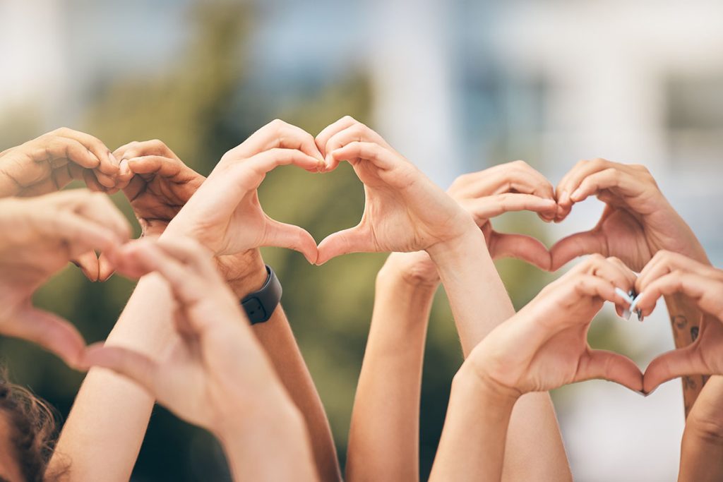 group of people making a heart shape with their hands