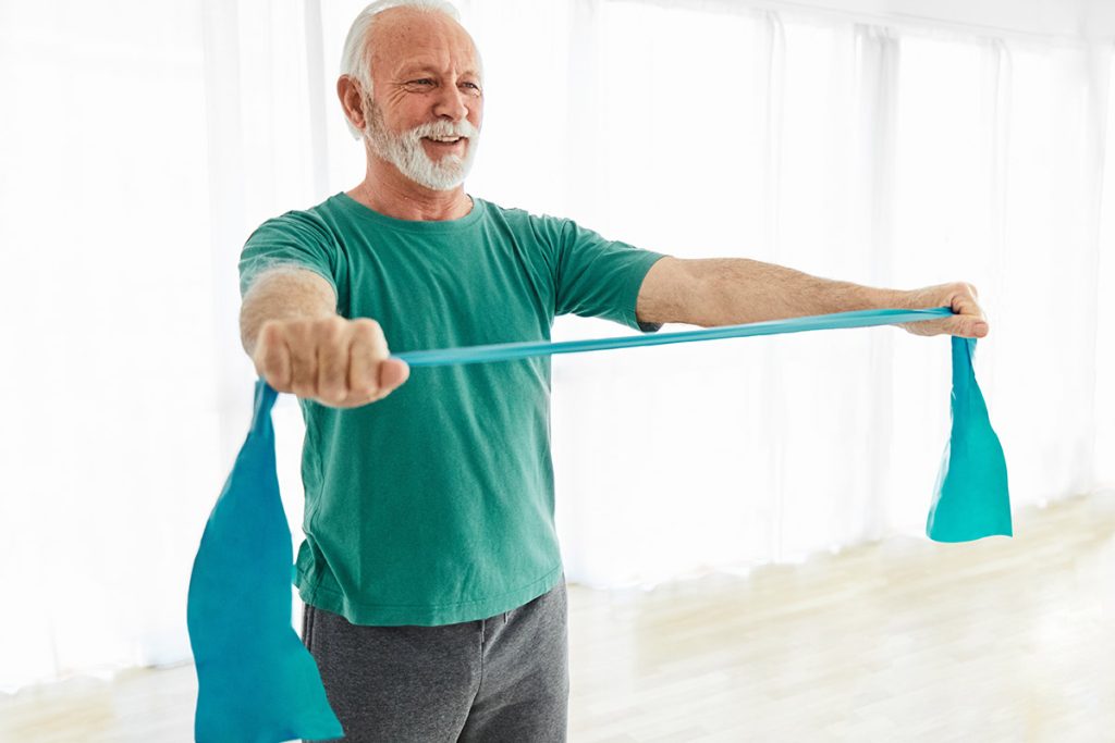 Senior man exercise stretching and exercising with resistance band 
