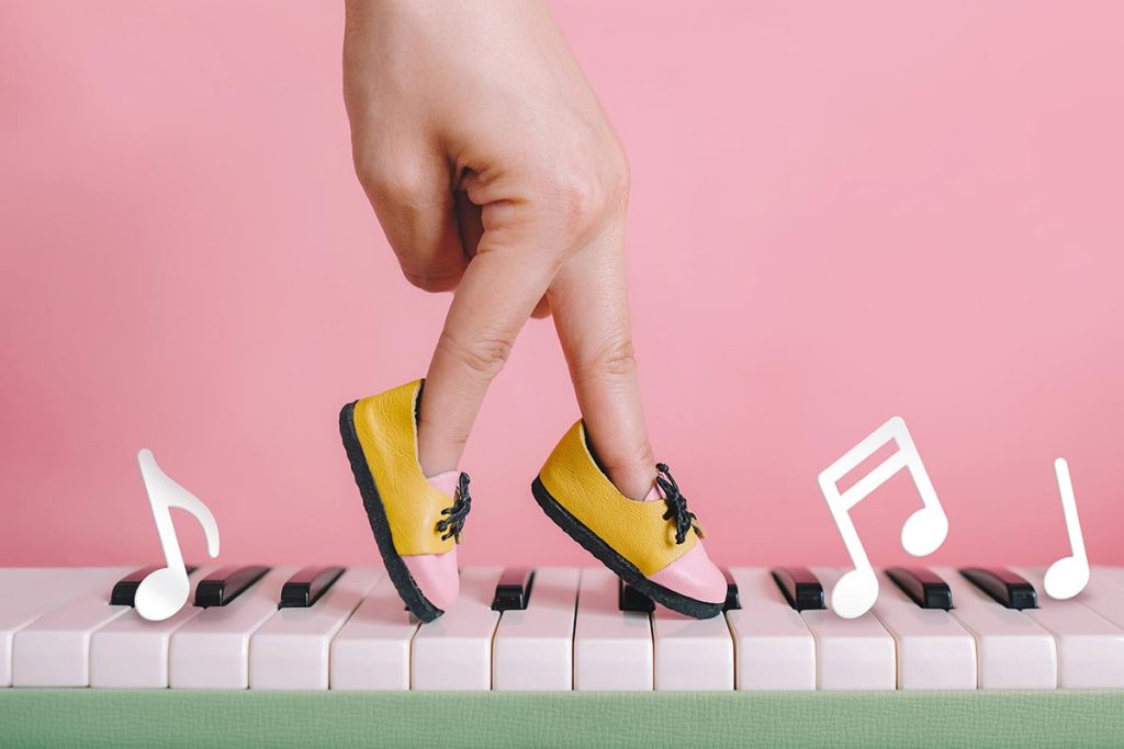 woman hand finger walking on piano between music note with shoe concept