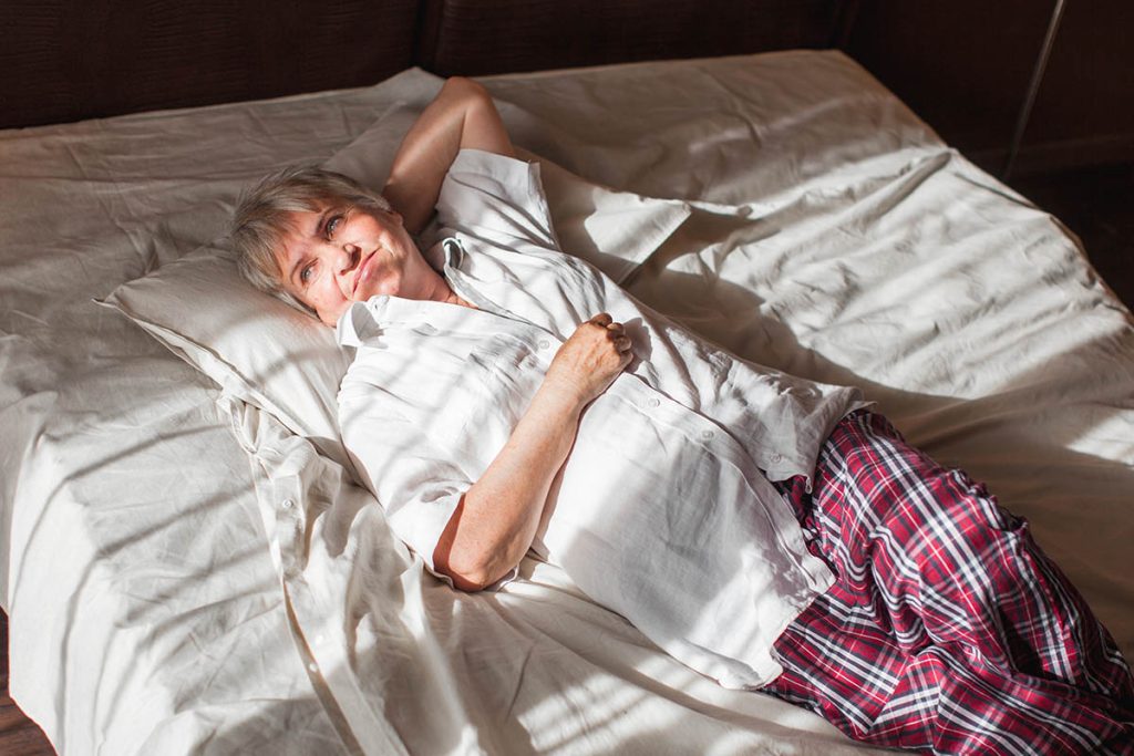 Portrait of senior woman lying in bed waking up fresh start 