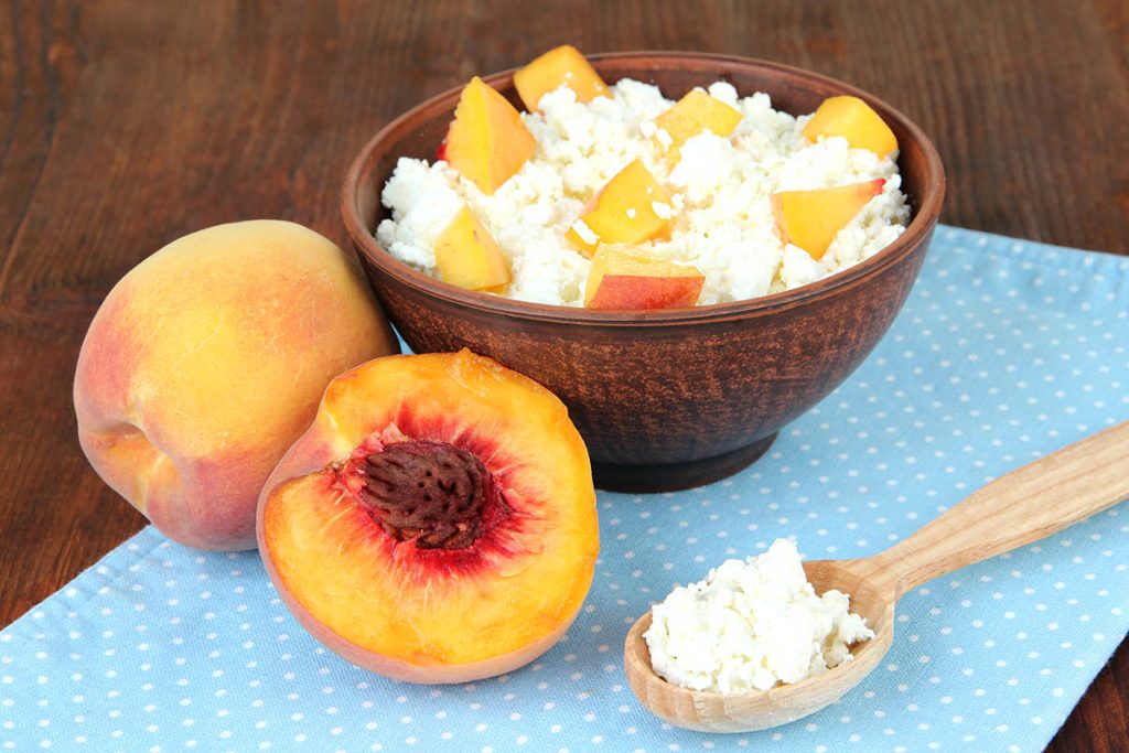 cottage cheese and fresh peaches,on wooden table background