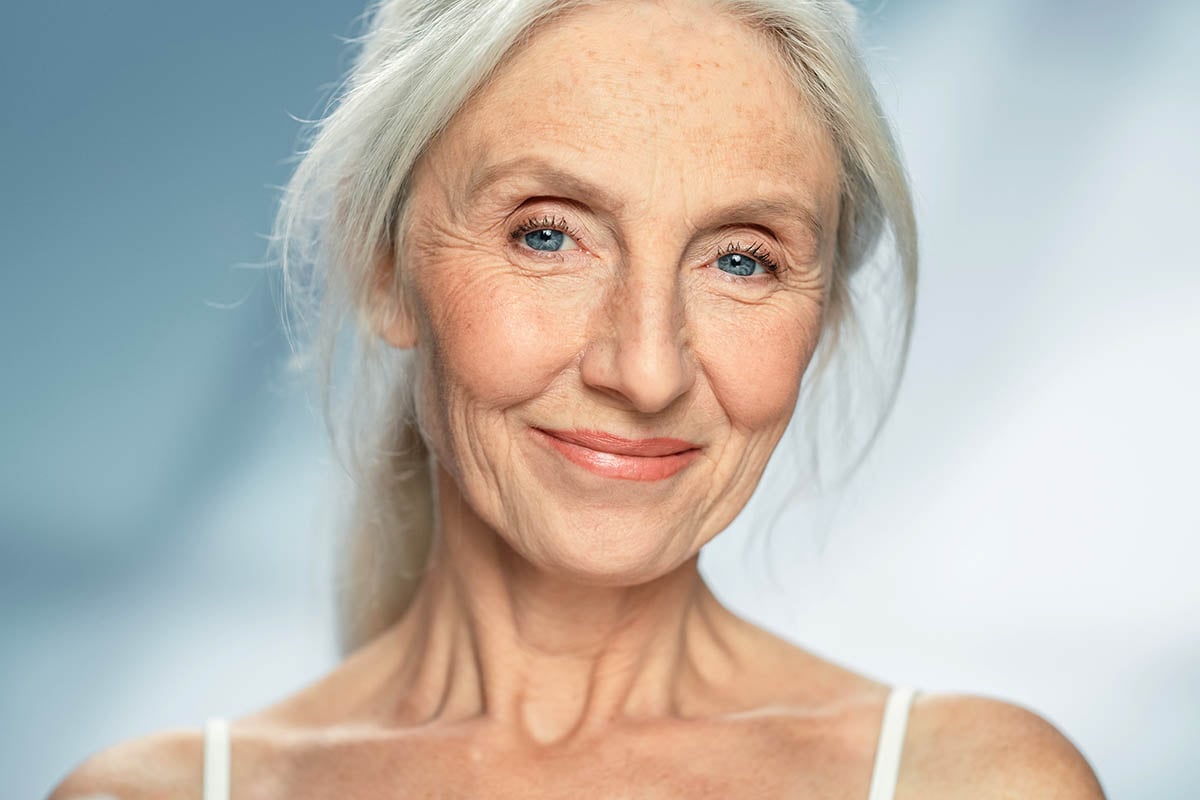 close-up portrait of older woman smiling with grey hair