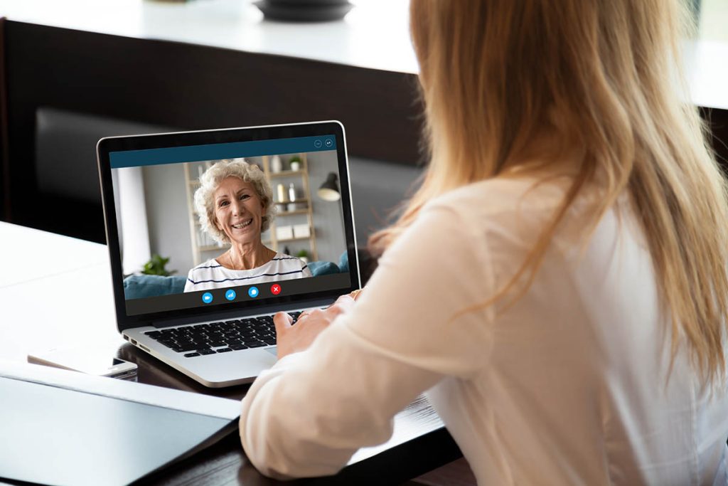 Focus on screen with happy middle aged woman making video call with grown up young daughter