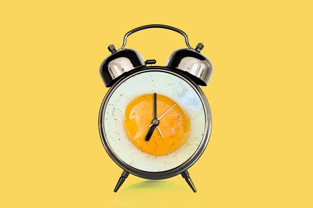 Fried egg and vintage alarm clock collage. Breakfast time concept