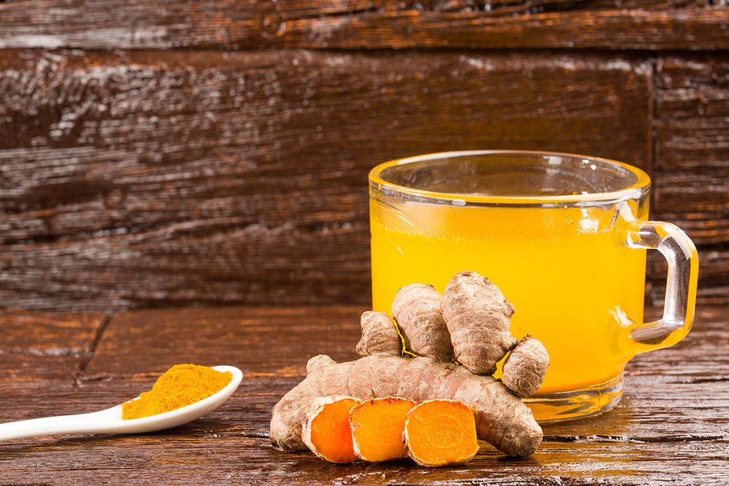 Turmeric and water, healthy drink - Wooden background