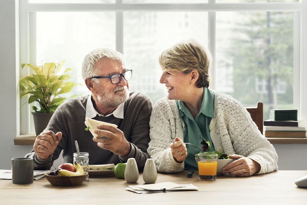 older couple smiling eating together