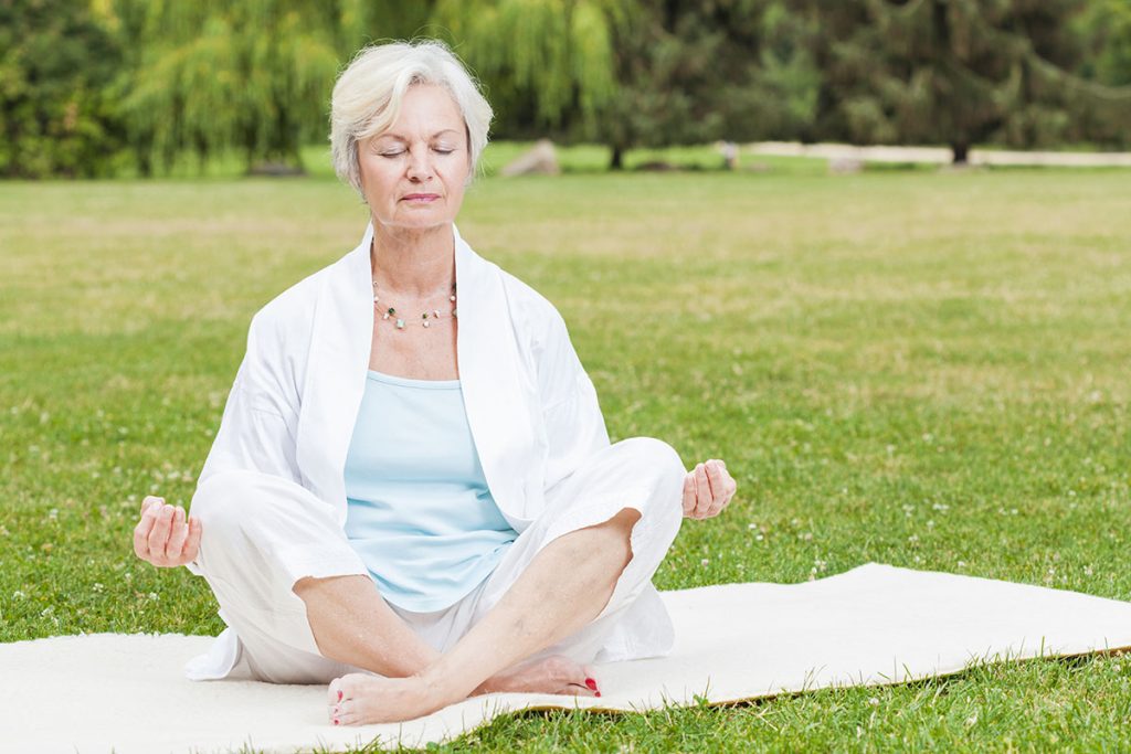Woman practicing yoga and tai chi outdoors