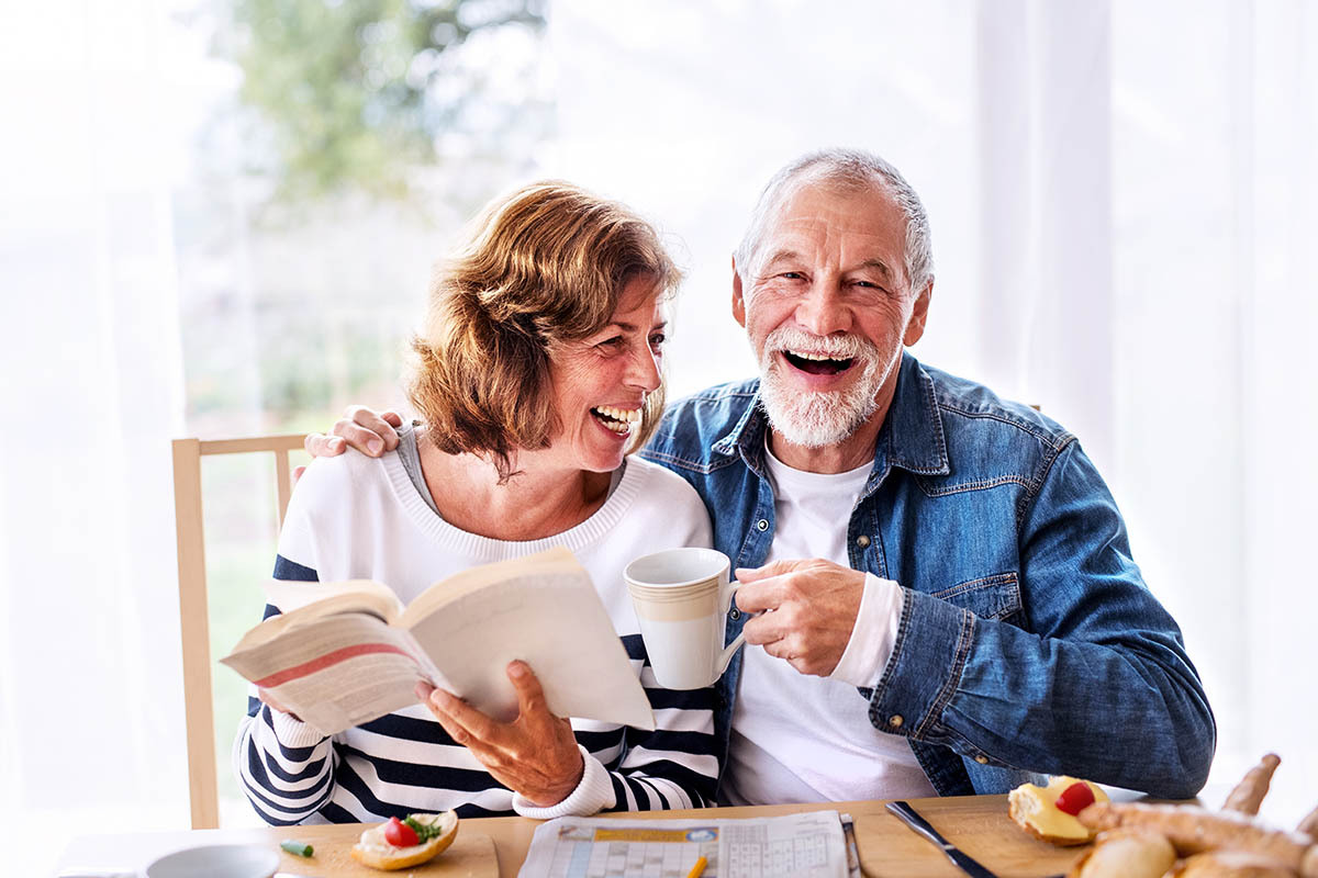 Older couple smiling together at breakfast outside