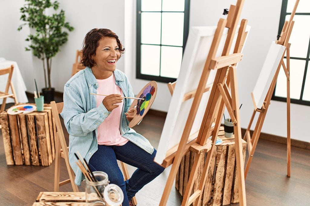Middle age artist woman smiling happy drawing at art studio.