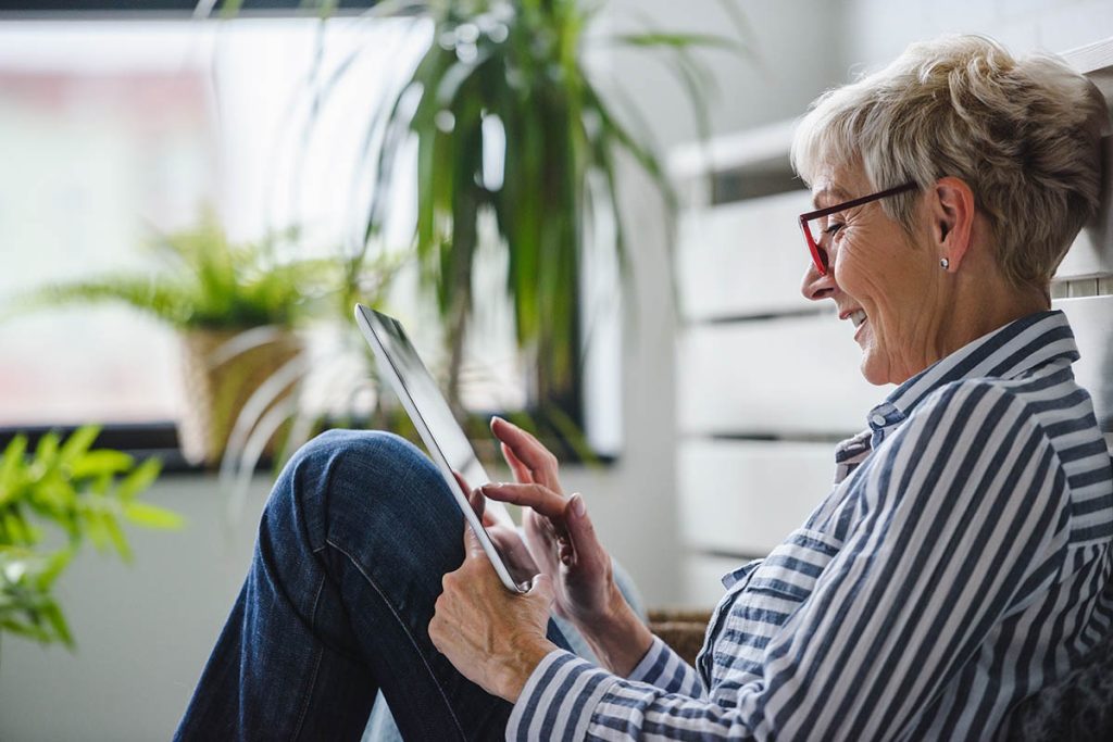 Senior woman using digital tablet at home. 