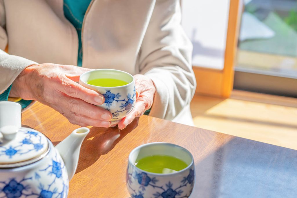 An old lady drinking Japanese tea in a Japanese-style room